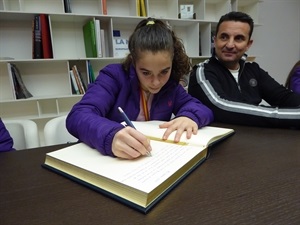 Marina Moreno, capitana del conjunto junior, escribiendo en el Libro de Honor de La Nucía