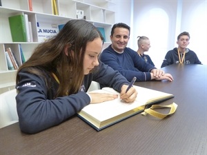 Los deportistas firmando en el Libro de Honor del Ayuntamiento de La Nucía.