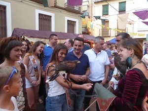 La reina Olga Fernández portando un ave rapaz junto al alcalde Bernabé Cano en la inauguración del Mercado Medieval