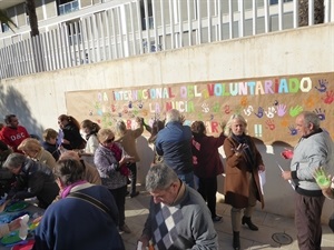 Cada huella de mano de un color para componer este mural solidario