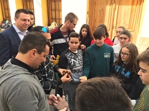 Los alumnos de 2º ESO enseñan sus guantes de pilota valenciana para raspall a Bernabé Cano, alcalde de La Nucía