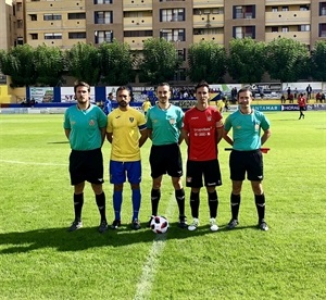 Los dos capitanes junto al trío arbitral