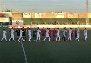 Los dos equipos saludándose en el inicio del partido