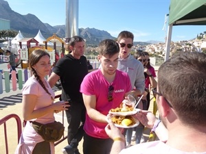 Los festeros con su ticket recogiendo su plato de paella