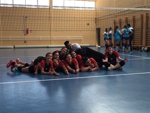 El Infantil A del Club Voley La Nucia celebrando la victoria con su entrenador Óscar Herreros