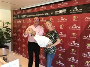 Emma Soler de la Penya Rebels junto a Manolo Alcalá, concejal de Sanidad recibiendo el jamón por ser la penya festera más solidaria