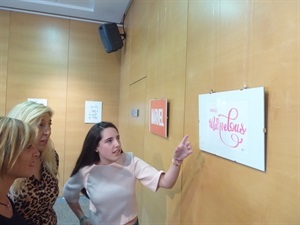 La joven artista nuciera Genoveva Abréu junto a Ofelia Jurado, dtora. Escuela de Dibujo y Pintura muestra una de sus obras a Mª Jesús Jumilla, concejala de Juventud en funciones de La Nucía