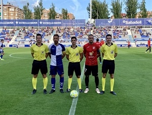 Los dos capitanes junto al trío arbitral