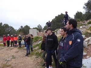 Bomberos y alumnos observando al perro de rescate intentando localizar las personas confinadas