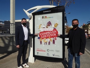 Frederik Herweijer, concejal de comercio y Bernabé Cano, alcalde de La Nucía junto a una de las marquesinas con la Campaña para fomentar las compras en el comercio local